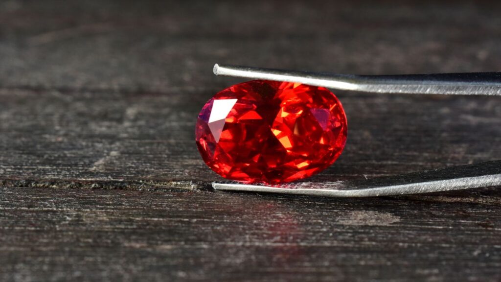 piedra roja sostenida por una pinza